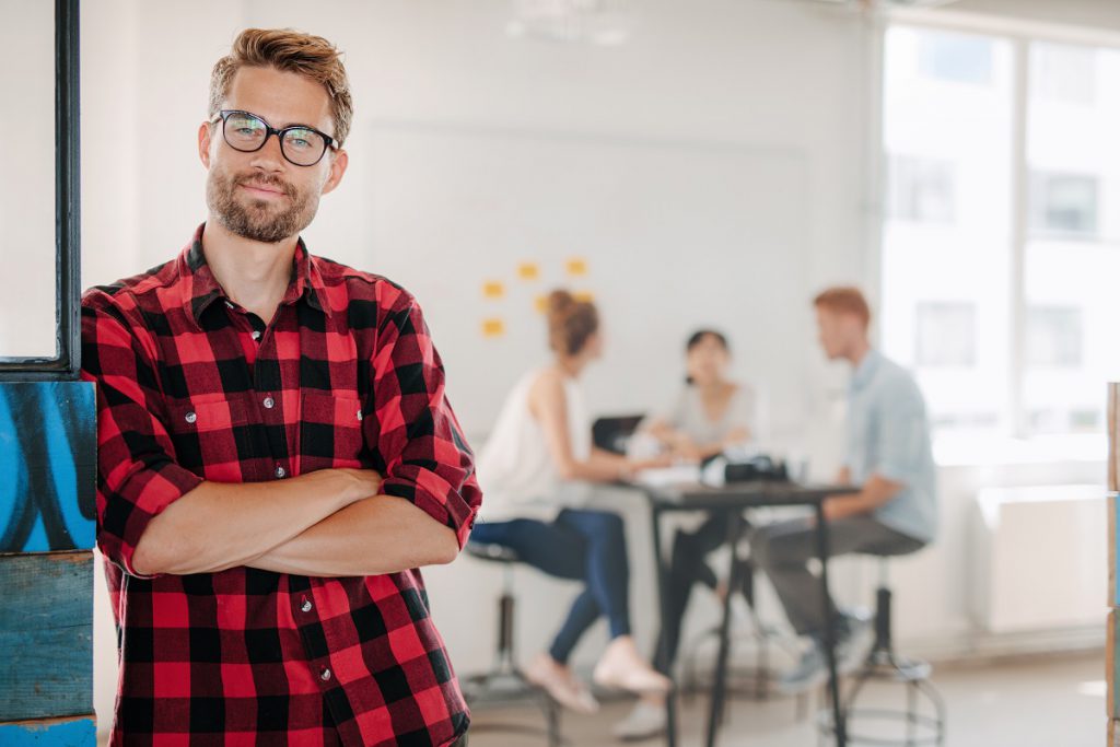 Relaxte man met een paar collega's op de achtergrond
